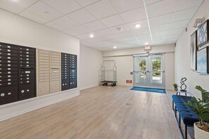 A lobby with mailboxes, a cart, and an exit door. - Waterwalk Extended Stay Kansas City - Overland Pk (Overland Park)