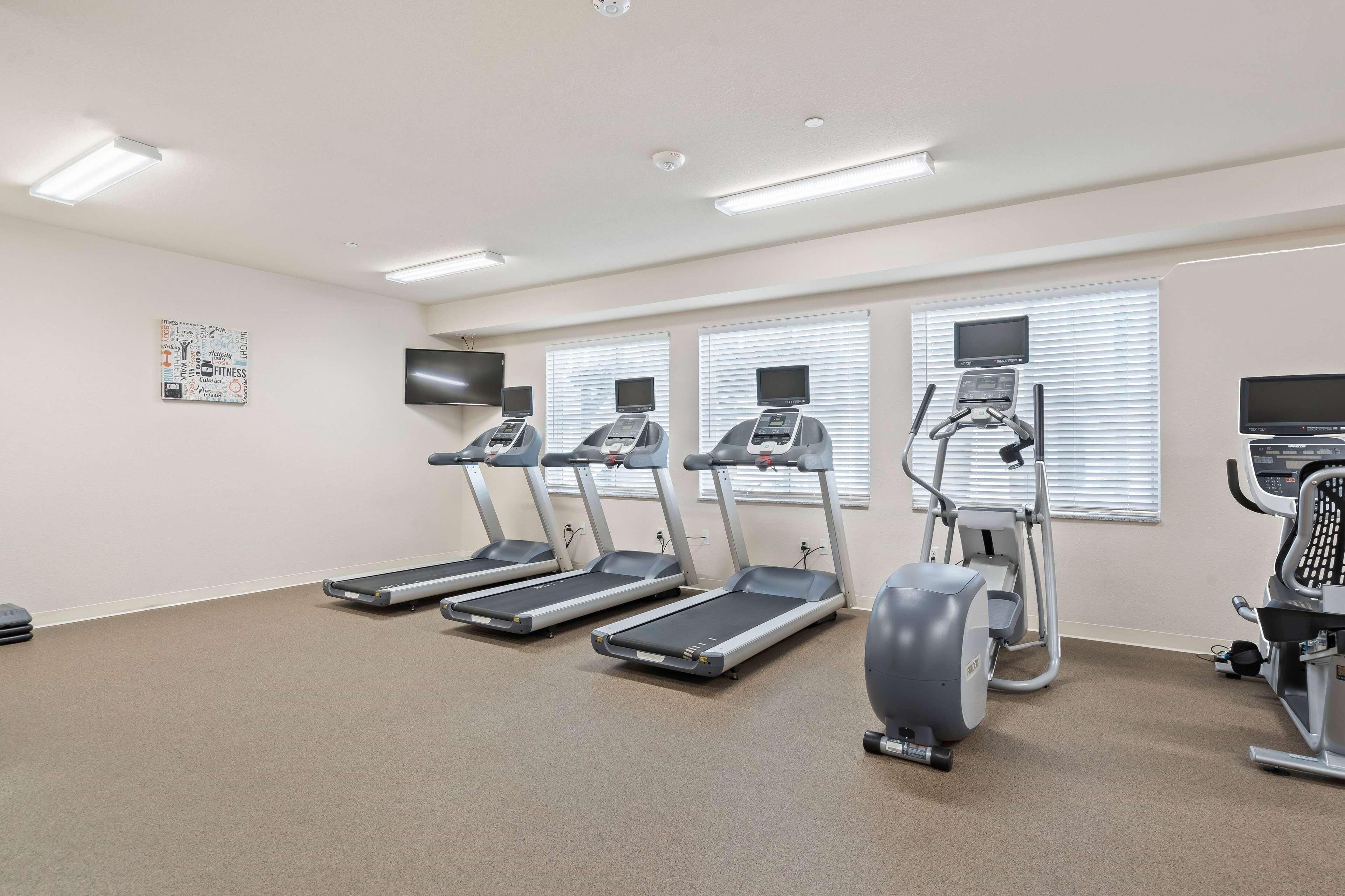 A fitness room with treadmills, an elliptical, and a stationary bike.