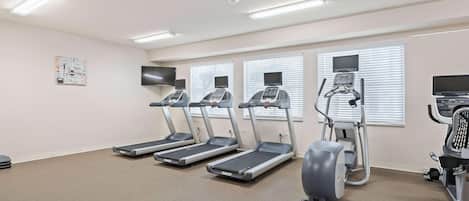 A fitness room with treadmills, an elliptical, and a stationary bike.
