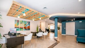 Un'accoglienza moderna con soffitto in legno, una scrivania della reception, sedie bianche e una parete d'accento blu.