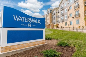Un letrero azul y blanco de Waterwalk con el eslogan 'Stay Live'.