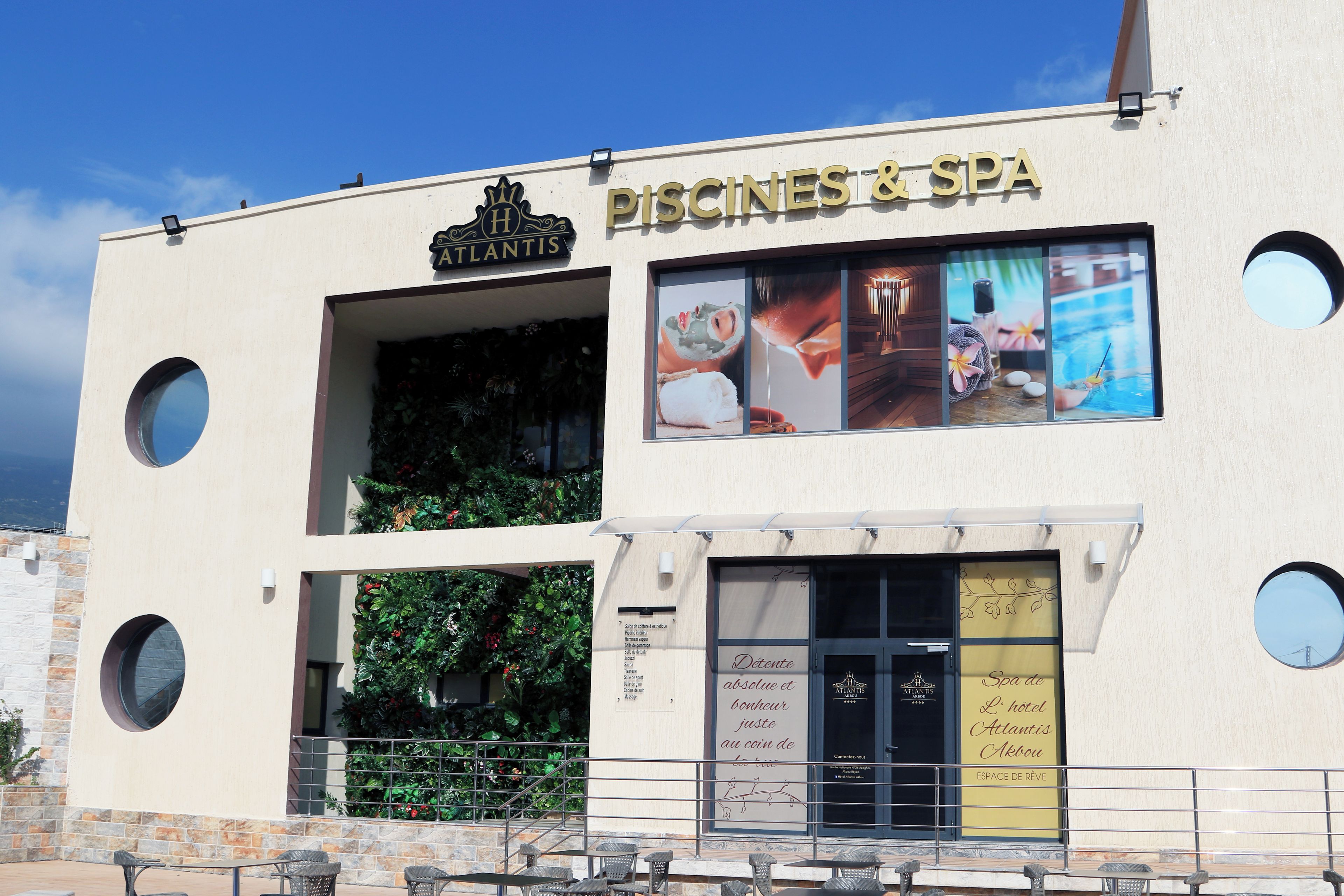 A building with a sign reading 'PISCINES & SPA' and a logo for 'Atlantis.'