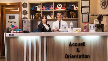 Una reception con un cartello che riporta 'Accueil & Orientation' e un espositore con asciugamani a forma di cuore.