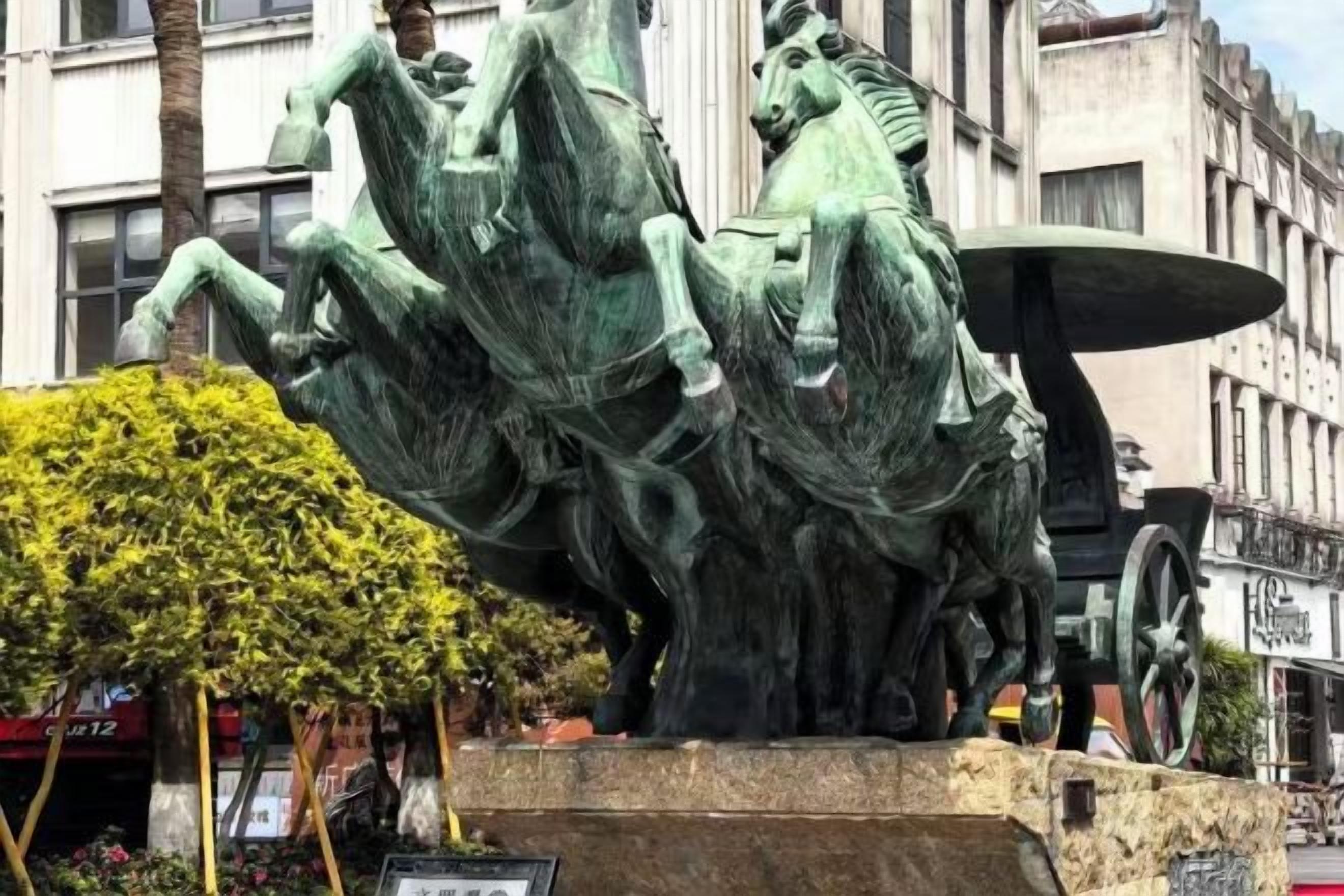 Una statua equestre in bronzo con una carrozza.