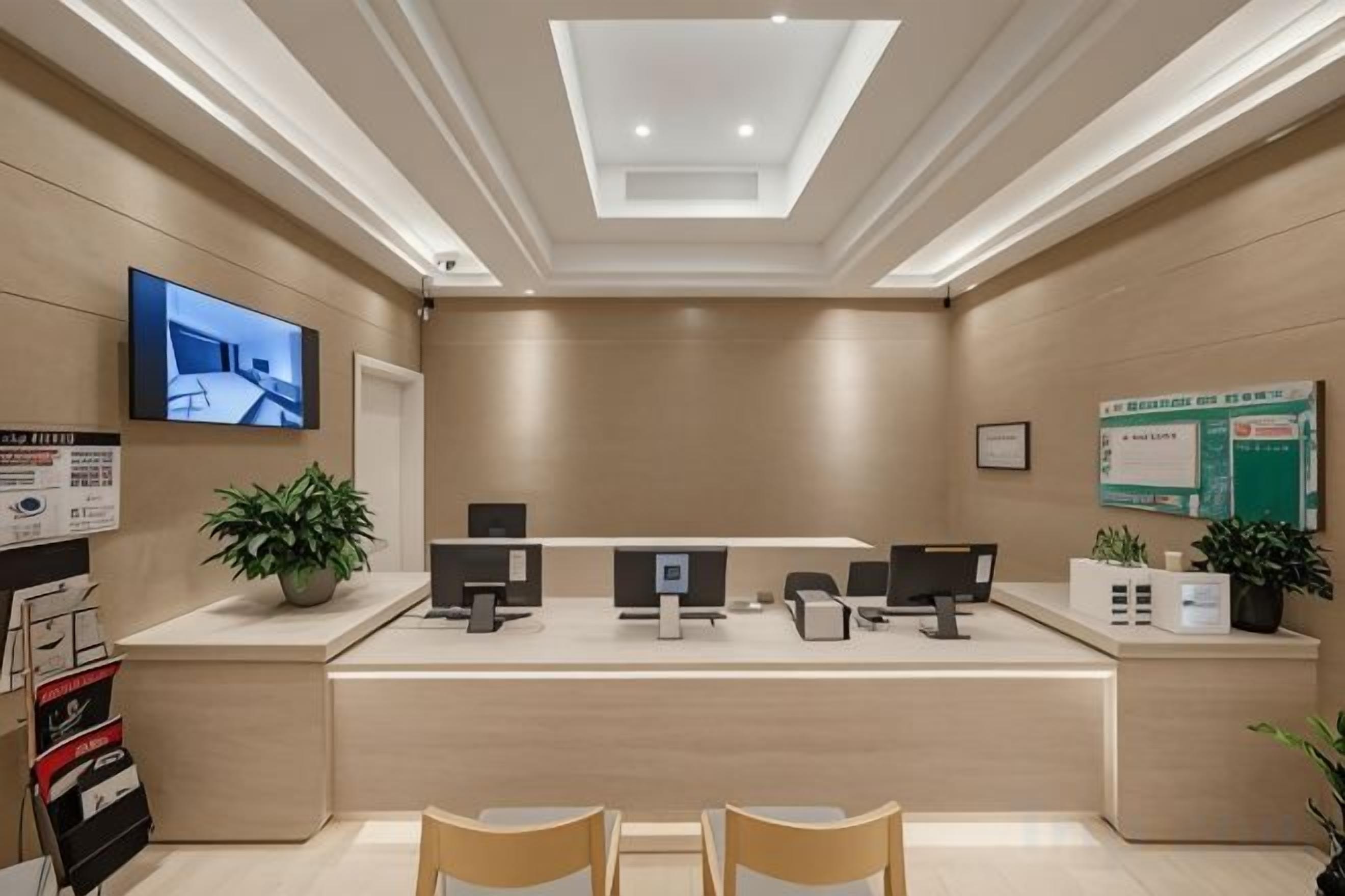 A reception area with a counter, computers, and seating.