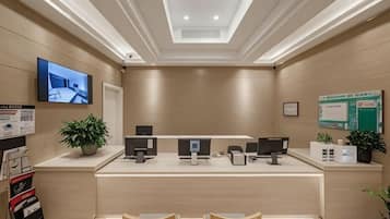 A reception area with a counter, computers, and seating.