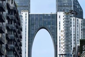A modern building with a large arched entrance, multiple floors, and balconies. - Xinyitian Hotel (Wenzhou Xueshan Road Wuma Street Branch) (Wenzhou)