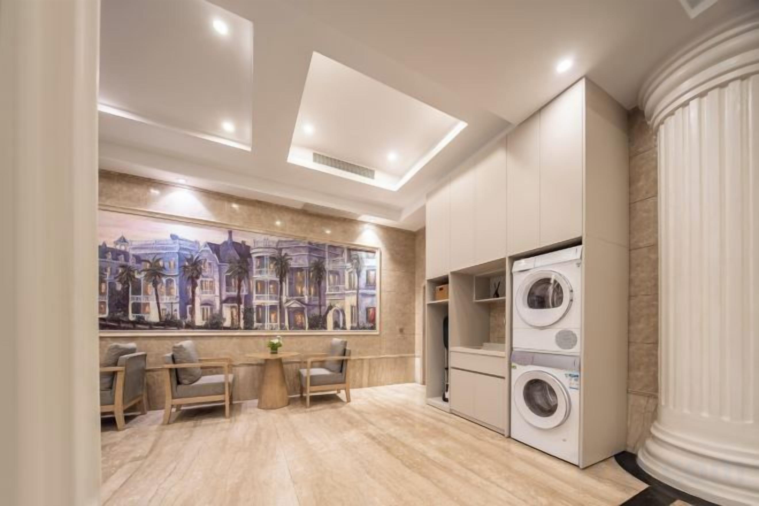 Un interior moderno con comedor, un cuadro grande y lavadora secadora incorporadas.