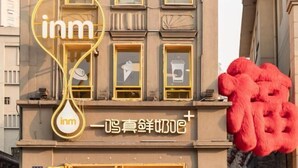 A building with a prominent 'inn' sign and a large red sculpture on the right. - Xinyitian Hotel (Wenzhou Xueshan Road Wuma Street Branch) (Wenzhou)
