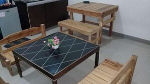 Ein Essbereich mit einem schwarzen Fliesen-Tisch, Holzstühlen und Bänken.