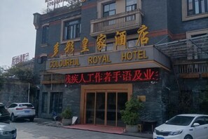 A hotel entrance with a sign that reads 'Colourful Royal Hotel' and a smaller sign below it that says 'Warrior Writer's Handwriting & Business'. - Colorful Royal Hotel (Qingzhen Time Guizhou Ancient Town) (Qingzhen)