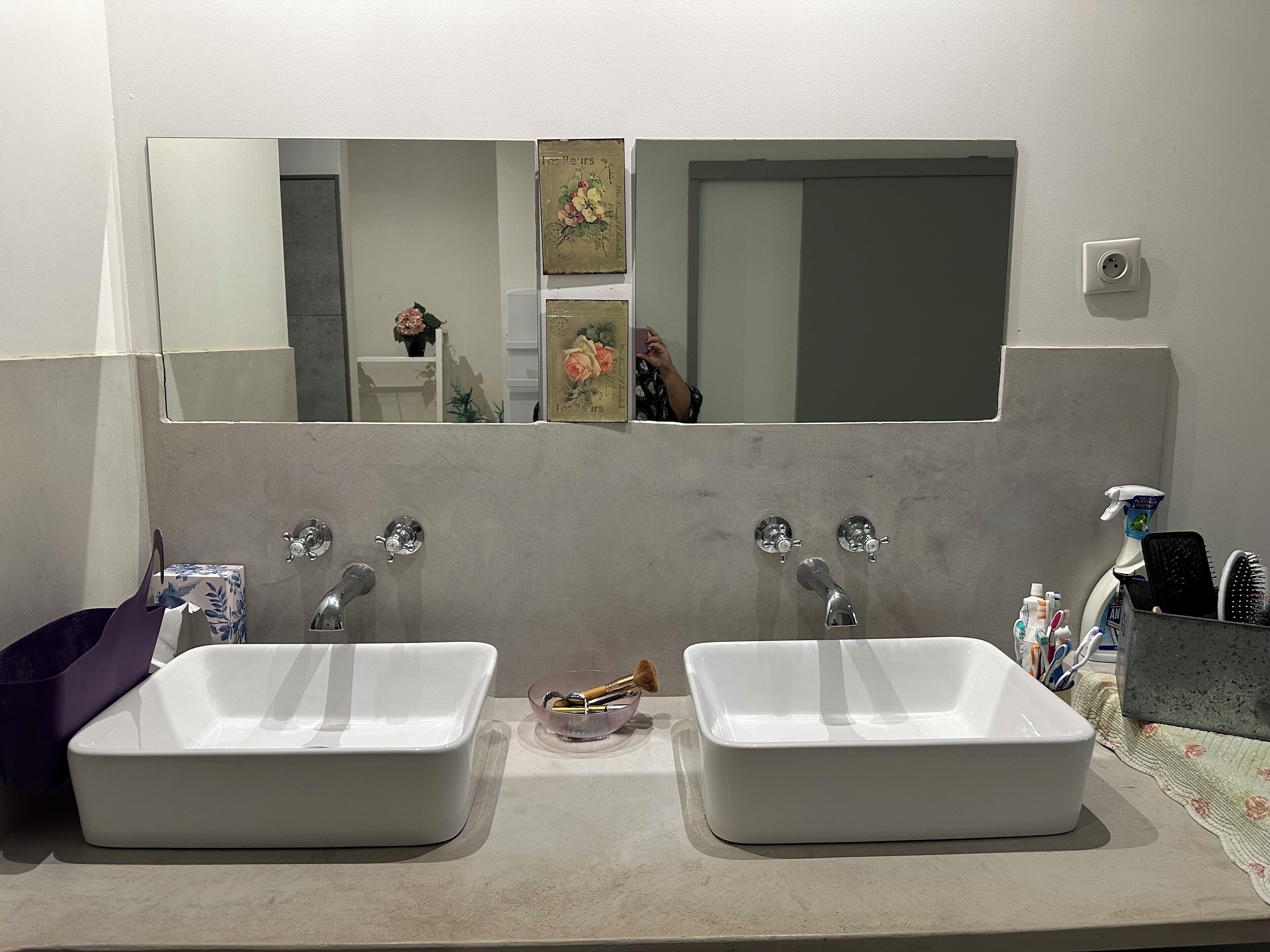 A bathroom with two white sinks, a mirror, and a towel rack.