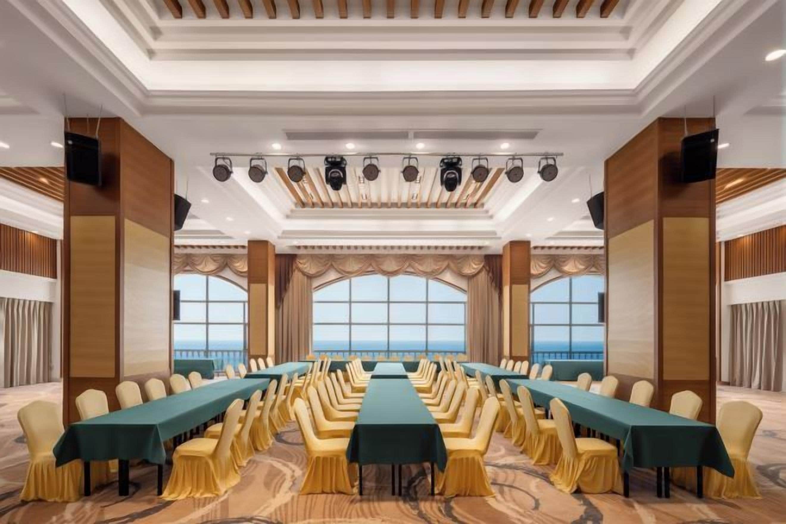 Une salle de conférence dotée d’une longue table, de nombreuses chaises et de grandes fenêtres.