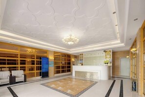 A hotel lobby with a reception desk, seating area, and a decorative ceiling. - Century Seaview Hotel (Nan'ao County)