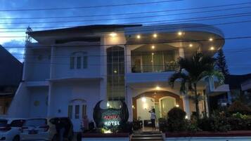 A hotel with a curved facade, large windows, and a prominent entrance.