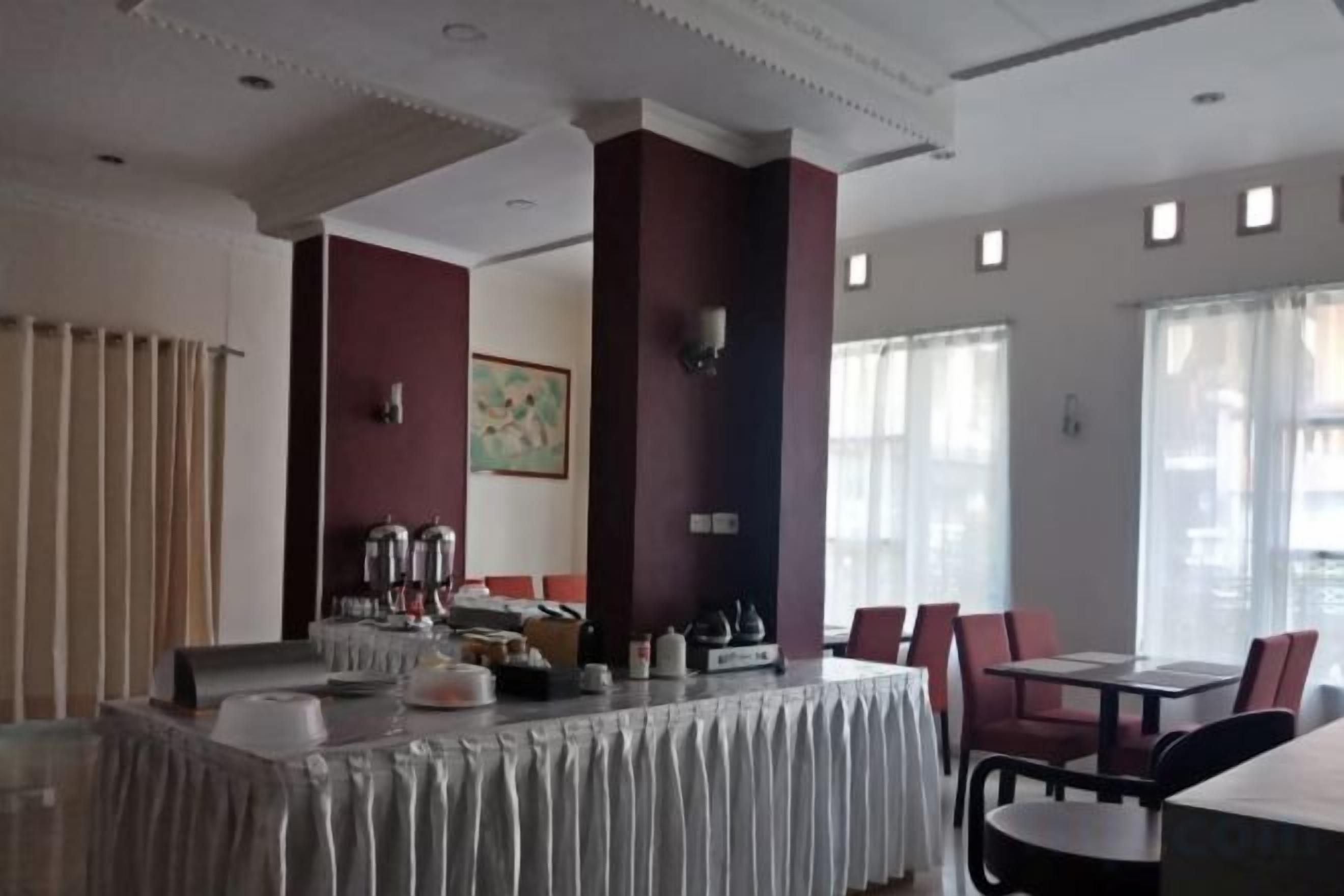 A dining area with a long table, chairs, and a buffet setup.