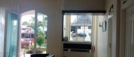 Un vestíbulo de hotel con puerta de vidrio de entrada, un área de descanso y vistas a la calle.