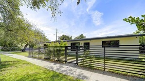 A single-story building with a flat roof, a metal fence, and a paved walkway. - Miami Design District/ Wynwood Townhome 298 (MIAMI)
