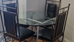 Zona pranzo con tavolo in vetro e sedie in metallo.