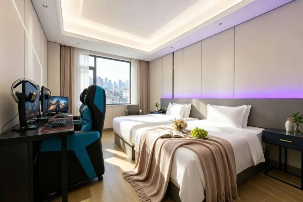 Ein modernes Hotelzimmer mit Bett, Schreibtisch und Blick auf die Stadt.