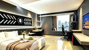 A modern hotel room with a bed, desk, and city view.