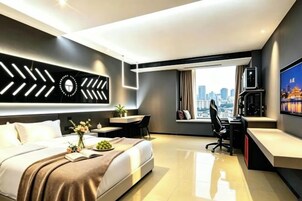 Habitación de hotel moderna con cama, escritorio y vista a la ciudad.