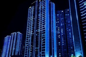 Un edificio de gran altura con varios pisos, iluminado con luces azules.