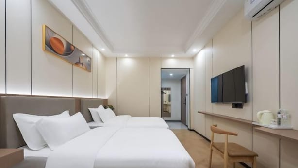 Une chambre d’hôtel avec un lit, une télévision, un bureau et une chaise.