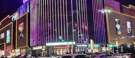 A multi-story building with illuminated signage and vertical light strips.