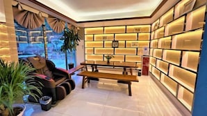 A modern interior with a sofa, a table, and a wall of illuminated storage boxes.