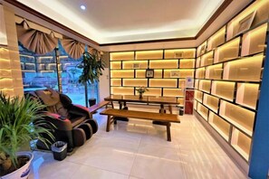 A cozy living area with a sofa, a wooden bench, and a bookshelf. - Wanli Hotel (Qinzhou)
