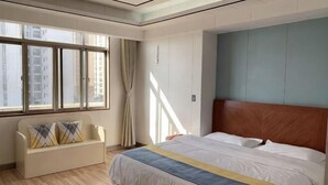 Une chambre d’hôtel avec un lit, un canapé, une fenêtre avec des rideaux et une vue sur des immeubles.