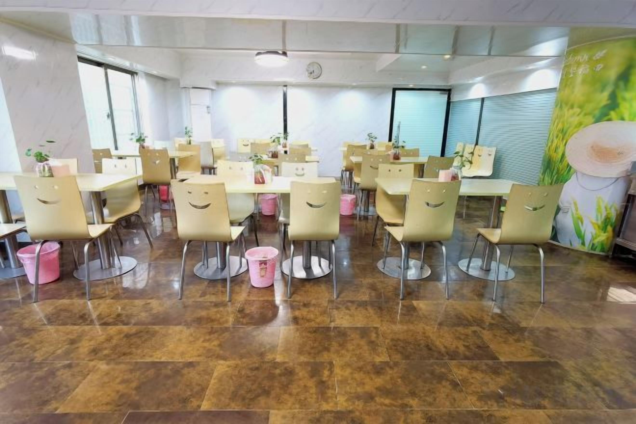 Une salle de conférence dotée de plusieurs tables et de nombreuses chaises, disposées en rangées.