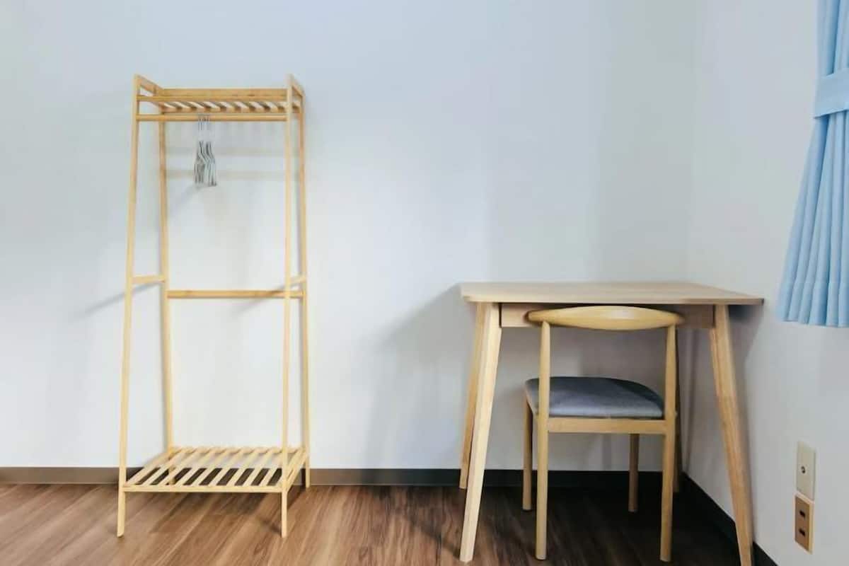 Een kamer met een houten plankunit, een klein tafeltje en een stoel.