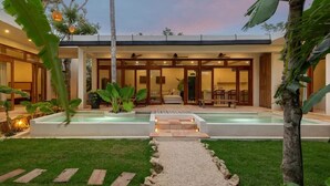 A modern house with a swimming pool, a patio, and a well-maintained lawn. - Villa Sanah 11 con alberca privada ubicada en Tulum (Tulum)
