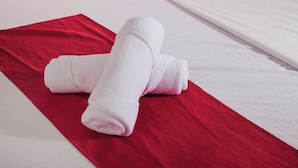A neatly folded white towel on a red and white bedspread. - Reddoorz @ Gabz K Travellers Inn Sorsogon City (Sorsogon City)