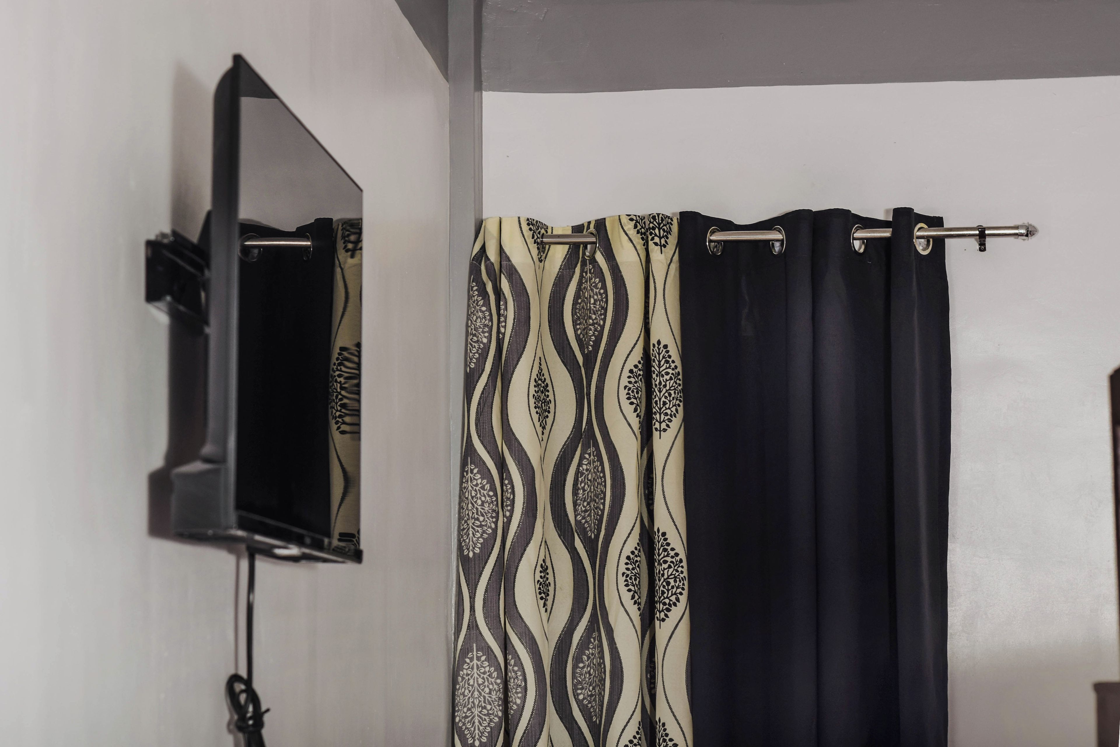 Un bagno con uno specchio, una tenda da doccia decorata e un portasciugamani.