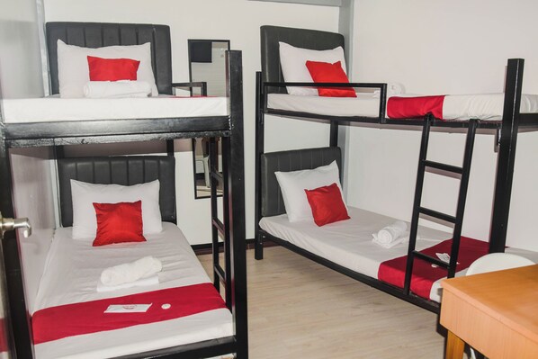 A dormitory room with bunk beds, each with a white mattress and red pillows. - Reddoorz @ Gabz K Travellers Inn Sorsogon City (Sorsogon City)