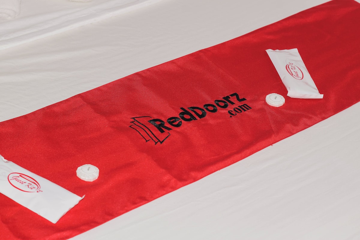 A red and white striped towel with the text "RedDoorz.com" and a logo.