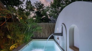 A modern outdoor pool with a water feature, surrounded by lush greenery and a thatched roof structure. - Villa Sanah 12 con alberca privada ubicada en Tulum (Tulum)