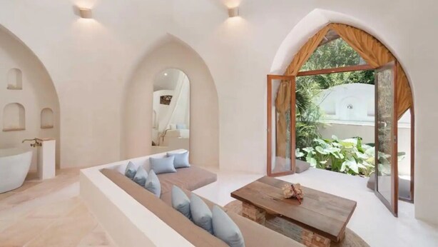 A modern interior with a large seating area, a wooden coffee table, and a view of greenery outside. - Villa Sanah 12 con alberca privada ubicada en Tulum (Tulum)