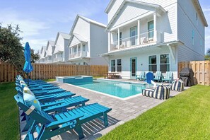 A residential property with a swimming pool, outdoor seating, and a wooden deck. - Miramar Beach Retreat, Pool, Hot Tub & Game Rooms (Miramar Beach)