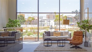 A modern living room with a large window, a sofa set, a coffee table, and a potted plant. - Cubo's Urban Sky Apartment Malaga View 17 / urban / air conditioning / free wifi / community pool (Málaga)