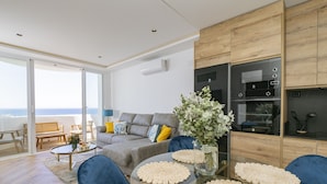 A modern living room with a glass table, blue chairs, a grey sofa, and a view of the sea. - Cubo's Vistalmar Calahonda Apartment / beach access / terrace / communal pool / free wifi (Mijas Costa)