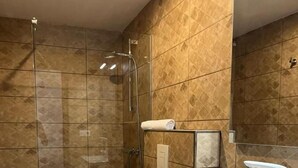 A modern bathroom with a glass-enclosed shower, a white toilet, and a sink with a mirror above it. - Hotel Key Reig (Almussafes)
