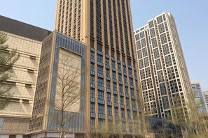 A tall building with a grid of windows and a reflective glass facade. - Xizhengjia Apartment (Guangzhou Pazhou Exhibition Wanshengwei Subway Station Branch) (Guangzhou)