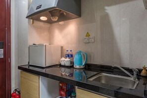 A kitchen with a stove, sink, and cabinets. - Xizhengjia Apartment (Guangzhou Pazhou Exhibition Wanshengwei Subway Station Branch) (Guangzhou)