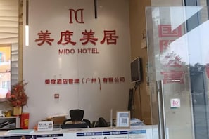 A reception desk with a sign for MIDO HOTEL, a reception area, and a glass partition. - Xizhengjia Apartment (Guangzhou Pazhou Exhibition Wanshengwei Subway Station Branch) (Guangzhou)
