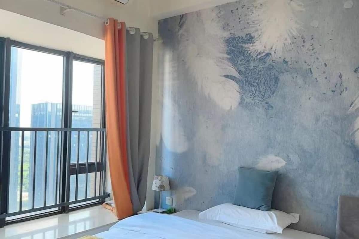 Quarto de hotel com uma janela ampla, uma varanda e uma parede com textura.