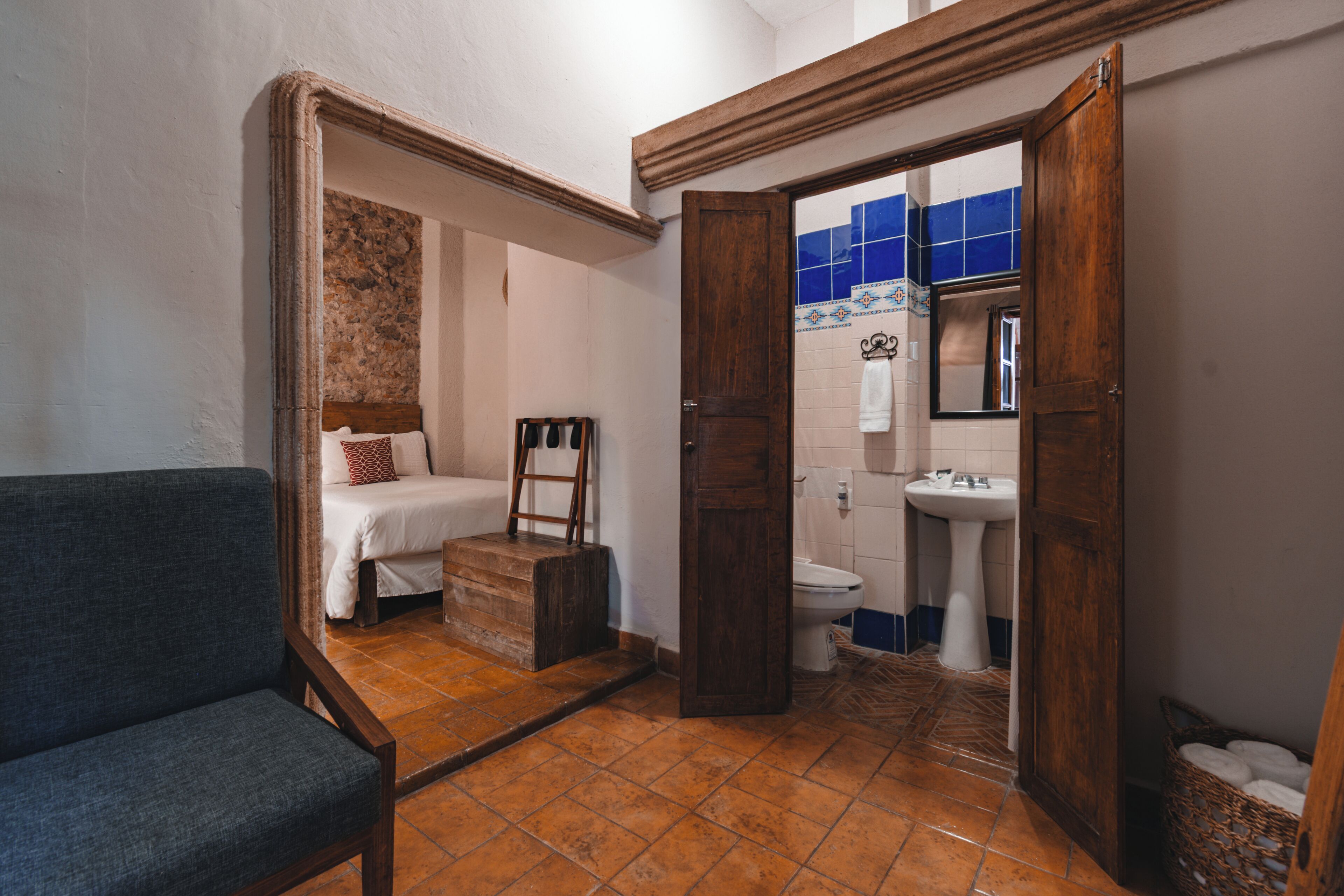 Un baño pequeño con inodoro, lavabo y cama individual.